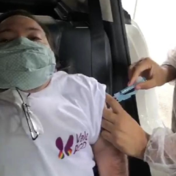 #Audiodescrição: Homem branco de cabelo castanho sentado dentro de um carro, ele usa máscara de proteção e camisa branca escrito: Vale PCD. Uma pessoa aplica vacina no braço dele.